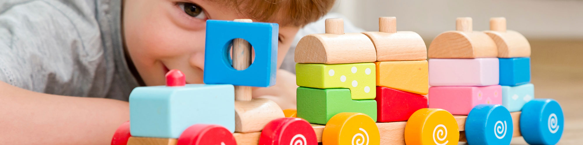 Young child playing with wooden train